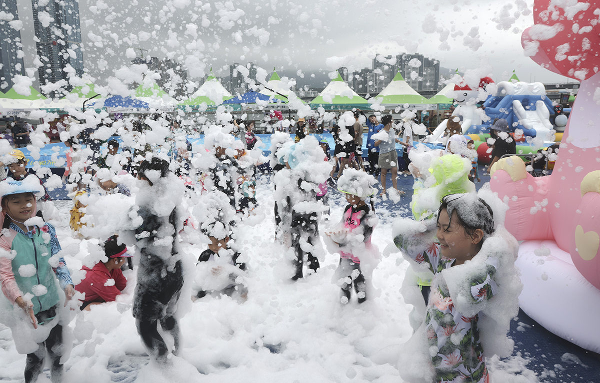Children on Aug. 16 play with natural bubbles harmless to humans at this year's Nam-gu District Water Festival (unofficial translation) at Yongho Byeolbit (Starlight) Park in Busan's Nam-gu District.