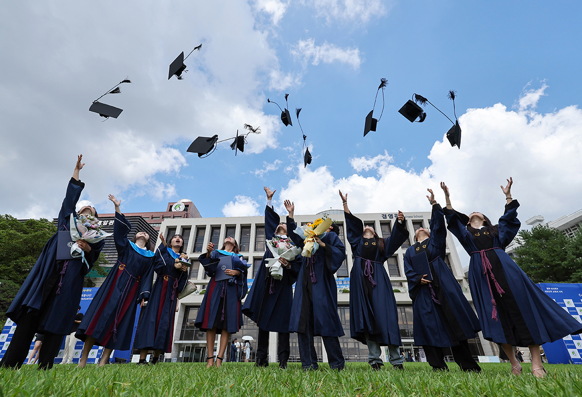 Graduating students at Sungkyunkwan University on Aug. 25 at their summer graduation ceremony do the traditional throwing of their caps into the air and take photos at their campus in Seoul's Jongno-gu District.