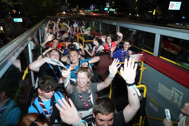 British scouts who withdrew from the World Scout Jamboree in Korea due to the heat on Aug. 6 cheer while riding a city tour bus in Seoul.