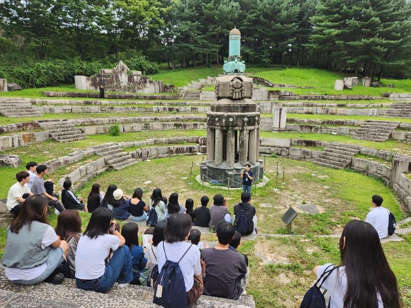 Participants in a history tour for descendants of Korean independence activists on Aug. 11 listen to curator Kim Jong-mun at the outdoor exhibition of the remains of the Japanese Government-General Building. (Park Jin-seo) 