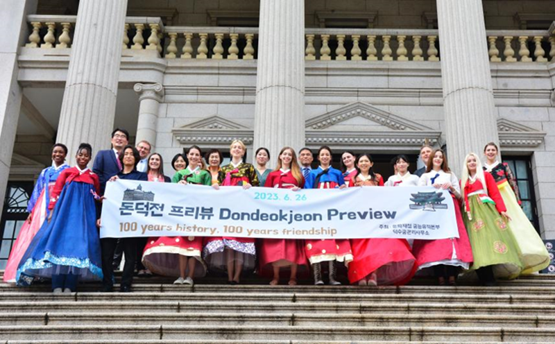 Foreign influencers on June 26 take a group photo in front of Dondeokjeon Hall at Deoksugung Palace in Seoul's Jung-gu District at a preview event for the hall's opening. (Cultural Heritage Administration)