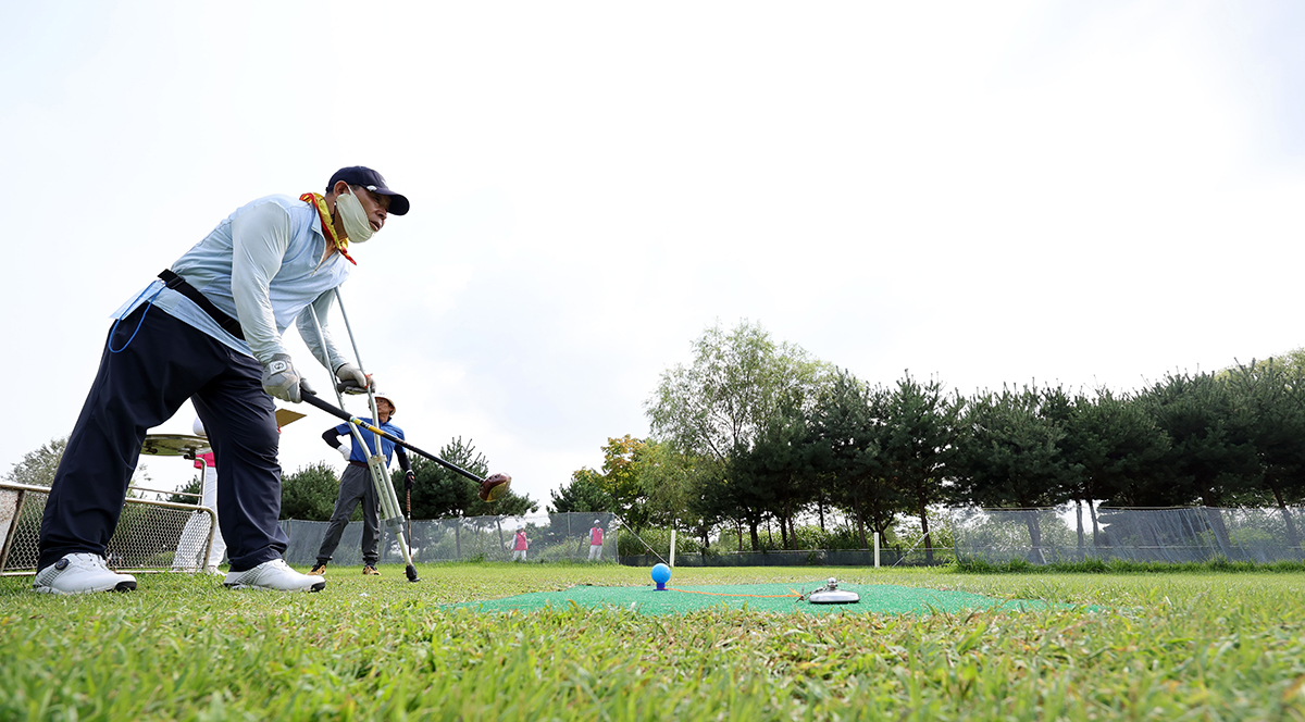 A competitor in the inaugural Seoul International Invitational Park Golf Tournament for People with Disabilities on Sept. 11 checks distance before taking a swing at World Cup Park Golf Course in the capital's Mapo-gu District.