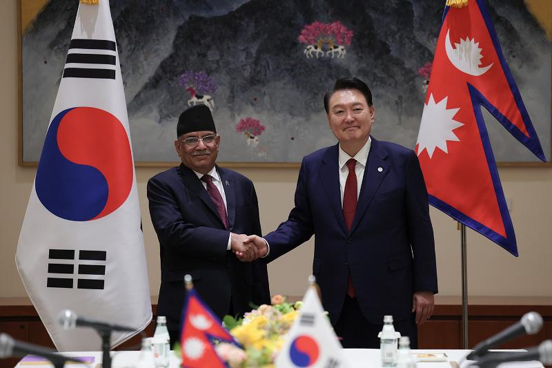 President Yoon Suk Yeol (right) on Sept. 21 poses for photos with Nepalese Prime Minister Pushpa Kamal Dahal in New York on the sidelines of the 78th U.N. General Assembly. 