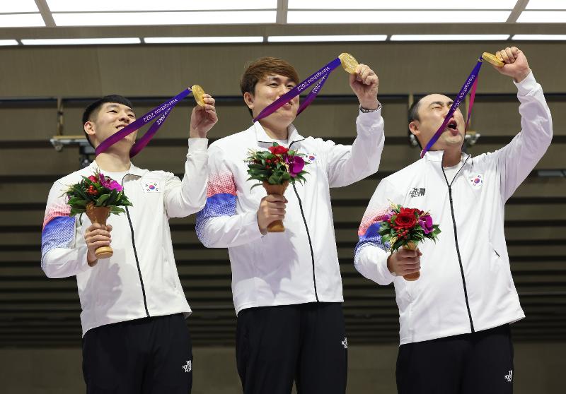 The men's shooting team (from left to right) comprising Kwak Yong-bin (Chungnam Sports Council), Jeong You-jin (Cheongju City Hall in Chungcheongbuk-do Province) and Ha Kwang-chul (Busan Metropolitan Government) on Sept. 26 hold up their gold medals at the Asian Games in Hangzhou, China, after winning the men's 10-m running target mixed run at Fuyang Yinhu Sports Centre.