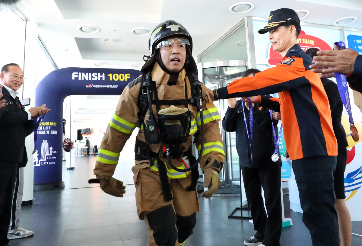 A firefighter on the morning of Oct. 25 in the National Firefighter Haeundae LCT Stair Climbing Competition at Landmark Tower of the skyscraper Haeundae LCT The Sharp in Busan's Haeundae-gu District crosses the finish line on the building's 100th floor.
