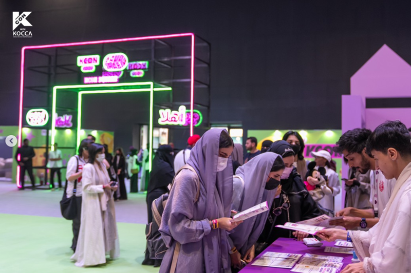 Visitors to the 2022 KCON Saudi Arabia in September last year look at a brochure on Korean culture and tourism in the Arab country's capital of Riyadh. (CJ ENM's official Instagram account) 