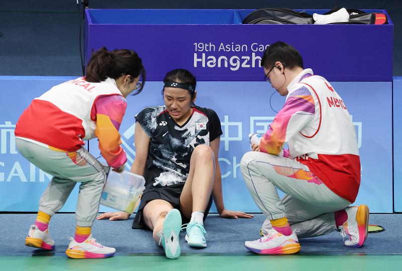 An Se-young (middle) on Oct. 7 suffers from knee pain during her match against China's Chen Yu Fei in the final of women's singles badminton at Binjiang Gymnasium. 