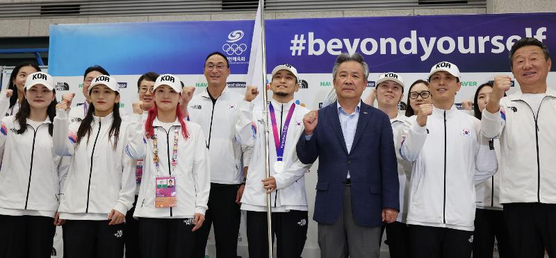The main batch of the Asiad delegation on Oct. 9 take a group photo at Terminal 1 of Incheon International Airport. 