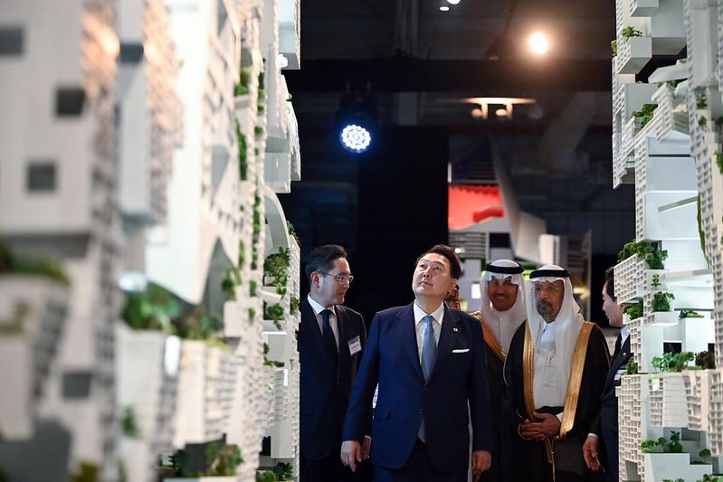 President Yoon Suk Yeol (left, front row) on Oct. 23 in Riyadh looks around an exhibition booth for the Neom smart city project with Saudi Minister of Investment Khalid A. Al-Falih at a ceremony marking the 50th anniversary of bilateral cooperation in construction.