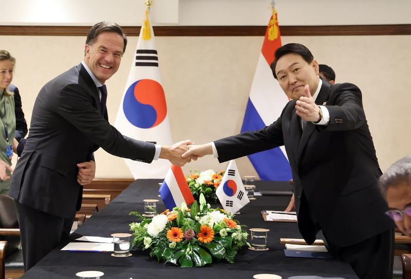 President Yoon Suk Yeol (right) and Dutch Prime Minister Mark Rutte on June 29 last year shake hands at their bilateral summit at a hotel in Madrid, Spain, on the sidelines of the annual NATO Summit. (Yonhap News)
