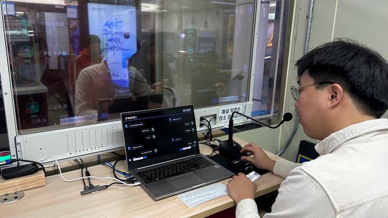 A subway worker on Dec. 12 talks with a foreign tourist using the AI Live-Translation System at Myeongdong Station in Seoul. 