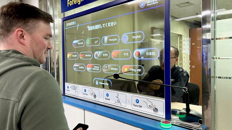 Tourist Eric Medema from the U.S. state of Michigan on Dec. 12 uses the AI Live-Translation System at Myeongdong Station in Seoul.