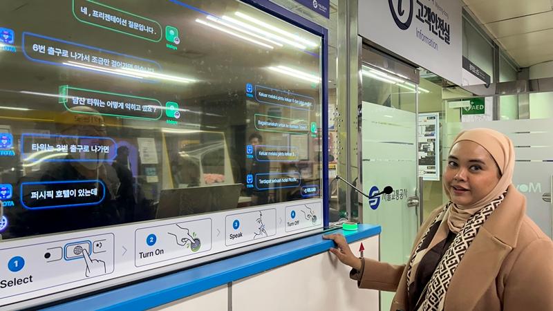 Tourist Nina Amila from Kuala Lumpur, Malaysia, on Dec. 12 uses the AI Live-Translation System at Myeongdong Station in Seoul.