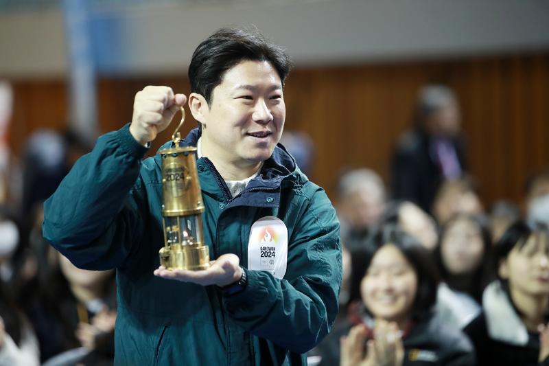 Jin Jong-oh, chair of Gangwon 2024's organizing committee, on Nov. 28 carries the torch as part of the 