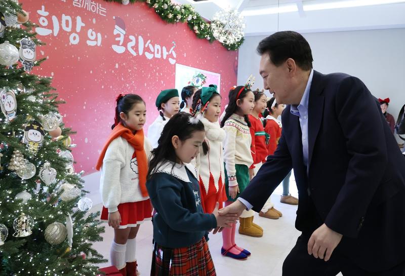 윤석열 대통령이 22일 서울 용산 대통령실에서 열린 '히어로즈 패밀리와 함께하는 꿈과 희망의 크리스마스'에서 캐럴 공연을 한 브릴란떼 어린이합창단원을 격려하고 있다. 연합뉴스