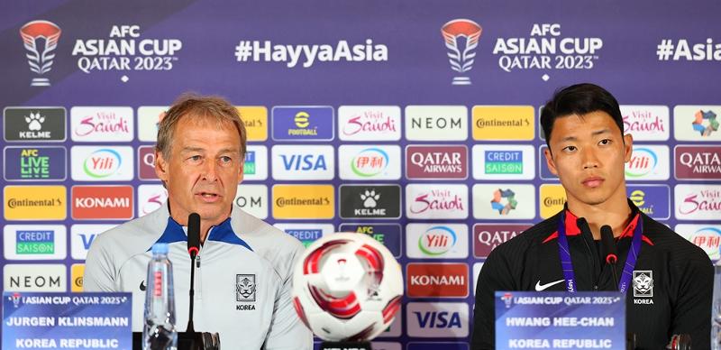 National soccer coach Jurgen Klinsmann (left) and striker Hwang Hee-chan on Jan. 14 speak at a news conference held at the main media center in Doha, Qatar, the day before Korea plays Bahrain in their opening game of Group E of the Asian Cup. (Yonhap News) 