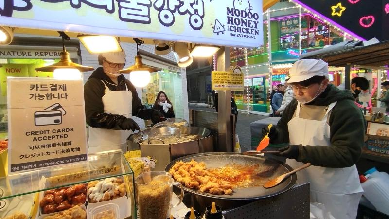 Street vendors in the tourist neighborhood of Myeong-dong in Seoul's Jung-gu District will soon begin accepting credit card payments. Shown is a food kiosk in the area with a sign reading 