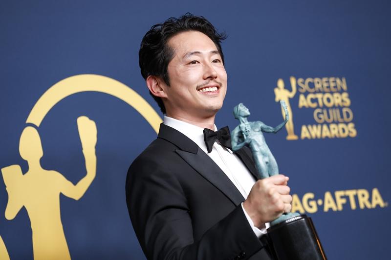 Steven Yeun on Feb. 25 holds his trophy after winning the Screen Actors Guild Award for Outstanding Performance by a Male Actor in a Television Movie or Limited Series for the Netflix drama 