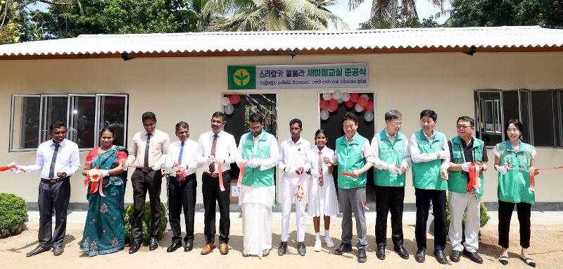 Gyeongsangbuk-do Province Gov. Lee Cheol-woo (fifth from right), local government officials and and residents of the Sri Lankan village of Walpula on May 26 last year cut the ribbon to celebrate the completion of a Saemaul Undong (New Community Movement) pilot village in Walpula. (Gyeongsangbuk-do Province) 