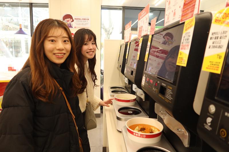 Japanese tourists on March 18 cook ramyeon at Ramyun Library using ramyeon cooking machines. 