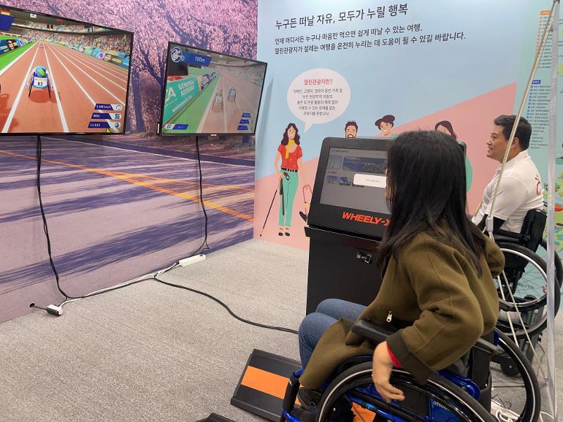 This year's Korea Travel Expo prioritizes the value of travel for all as shown by a visitor playing an extended reality game of wheelchair racing..