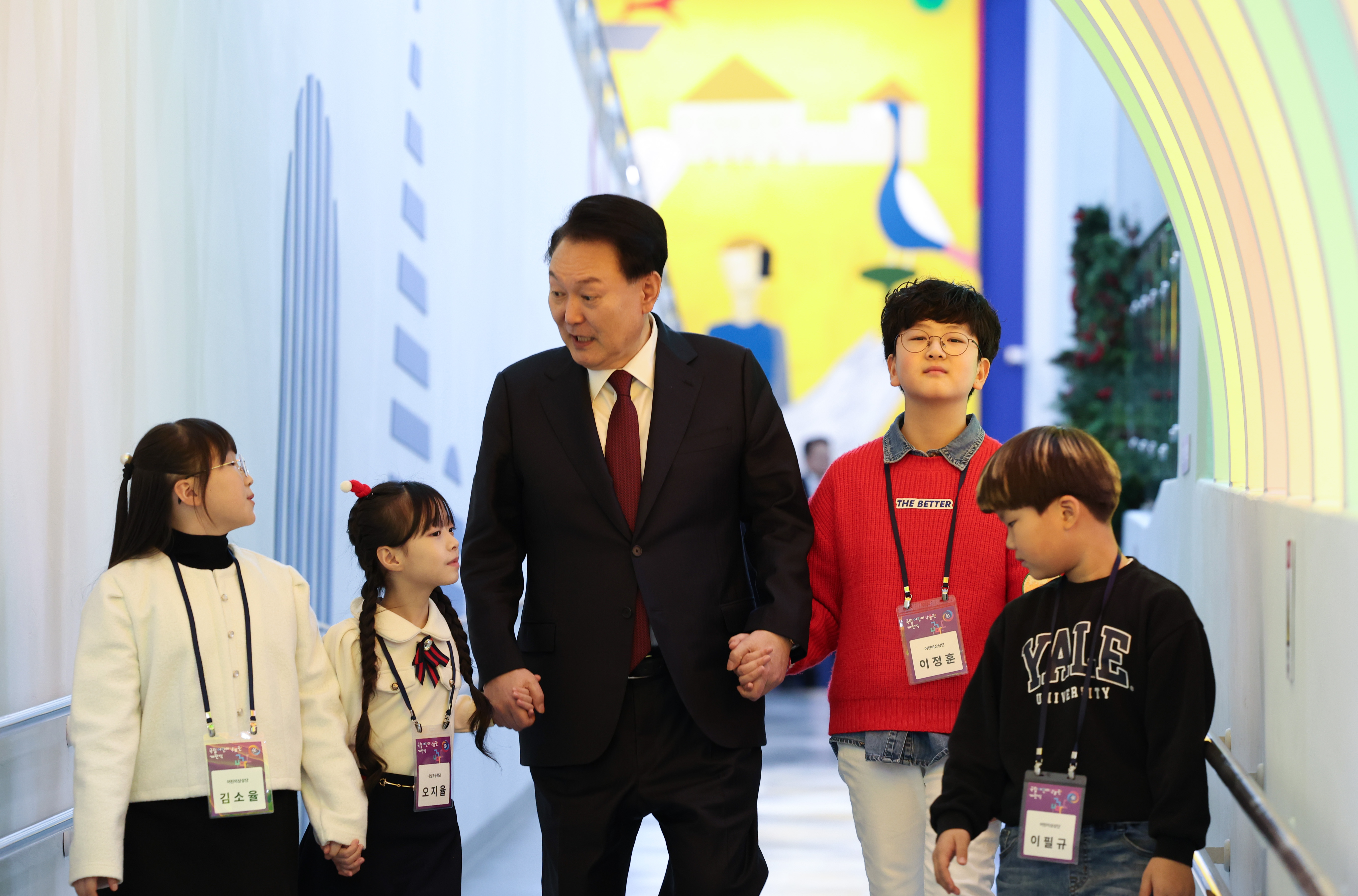 President Yoon on Dec. 16, 2023, holds hands with children while touring the exhibition hall of the National Children's Museum during the latter's opening ceremony at the National Museum Complex of Korea in Sejong. 