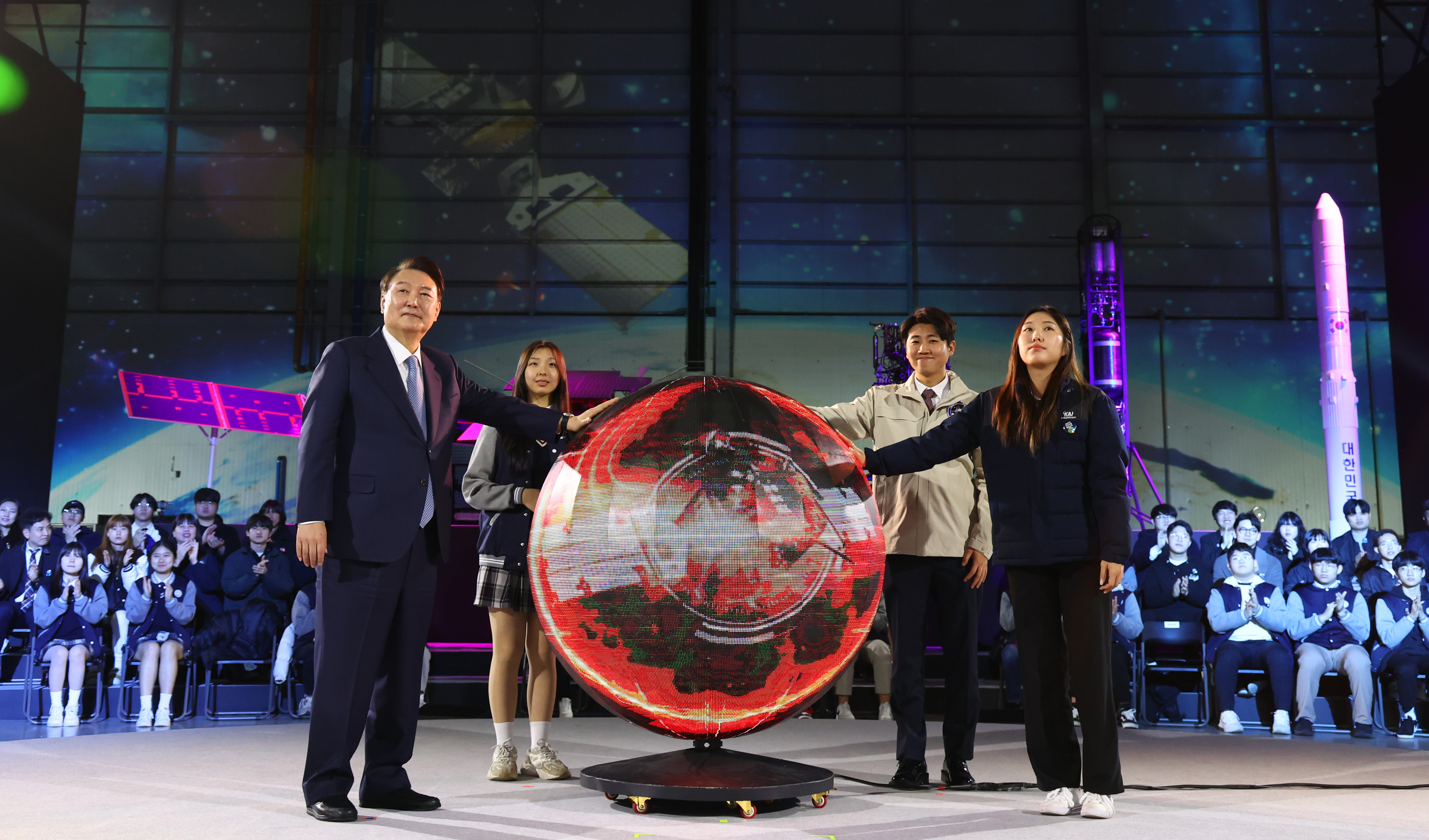 President Yoon on March 13 places his hands on a metal globe as part of a performance at the launching ceremony for a new national cluster for the space industry at Korea Aerospace Industries in Sacheon, Gyeongsangnam-do Province.