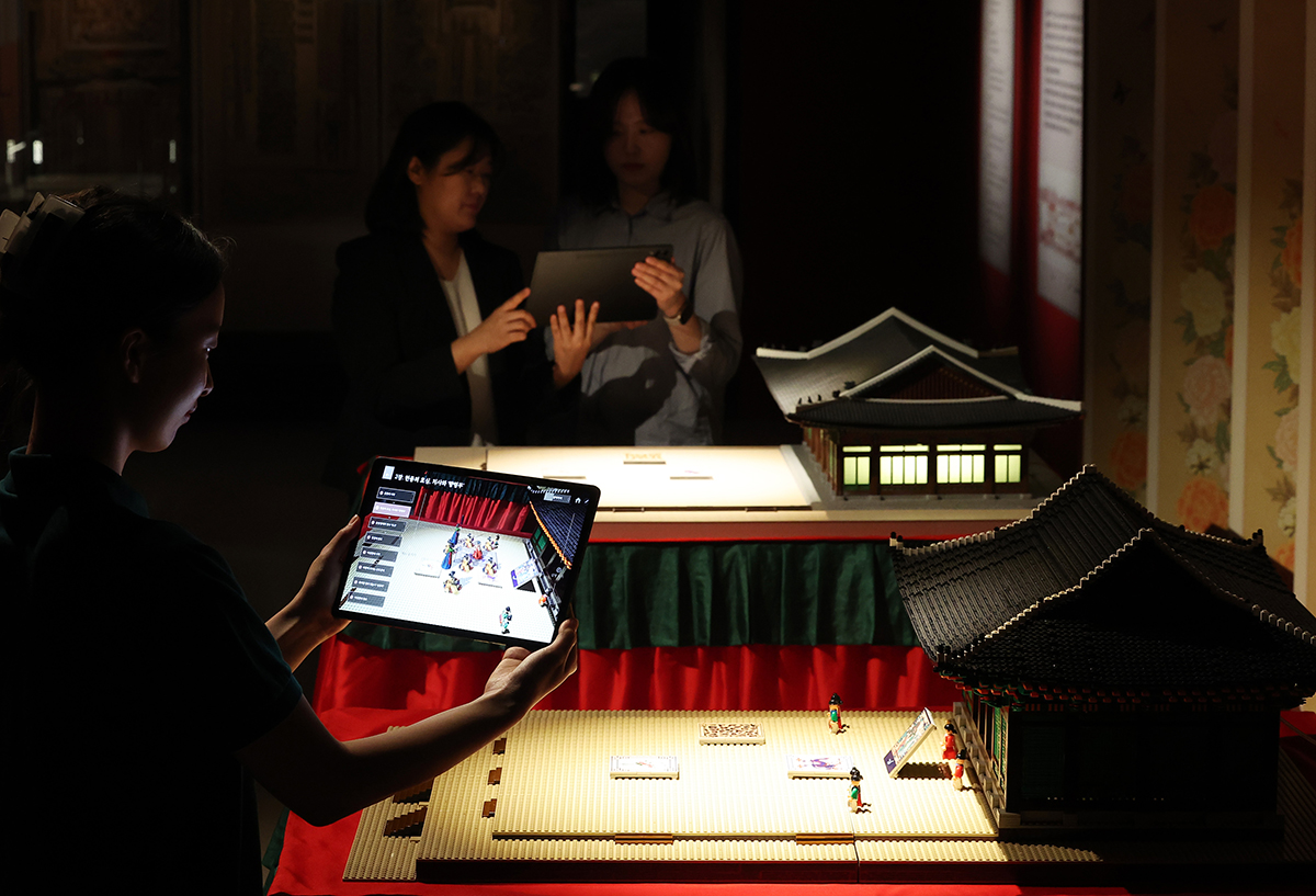 Visitors on May 23 look at display items utilizing augmented reality at the exhibition 