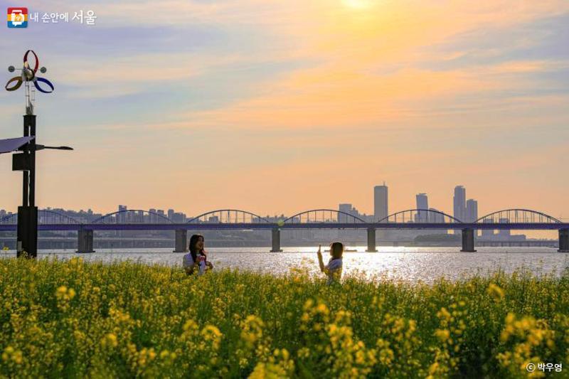 ▲ 8일 서울시 서초구 서래섬에서 한강과 노을을 배경으로 사진을 찍고 있는 시민들. 서울시 시민기자 박우영