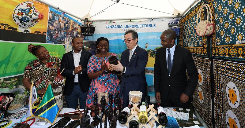 Minister of Foreign Affairs Cho Tae-yul (second from right) on May 10 at Gwanghwamun Square in central Seoul listens to an explanation about a traditional handicraft at a booth of the Tanzanian Embassy on the opening day of the 2024 Africa Festival. 