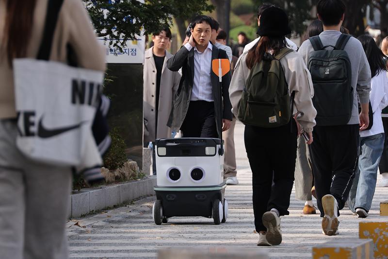 A new public project will support software development in all sectors ranging from robotics, medicine and climate to transportation and logistics. Shown is a self-driving delivery robot on Oct. 31 last year using address information to deliver its package in a demonstration at Konkuk University in Seoul's Gwangjin-gu District. (Yonhap News) 