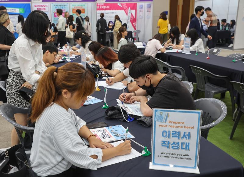 The Ministry of Education and Jeollabuk-do Province on June 27 will host a job fair for international students at Jeonju University in the provincial capital of Jeonju. Shown are attendees on July 20 last year customizing their resumes at a job fair for such students interested in getting a region-specific visa at the Busan Port International Exhibition & Convention Center, aka BPEX, in Busan's Dong-gu District. (Yonhap News) 