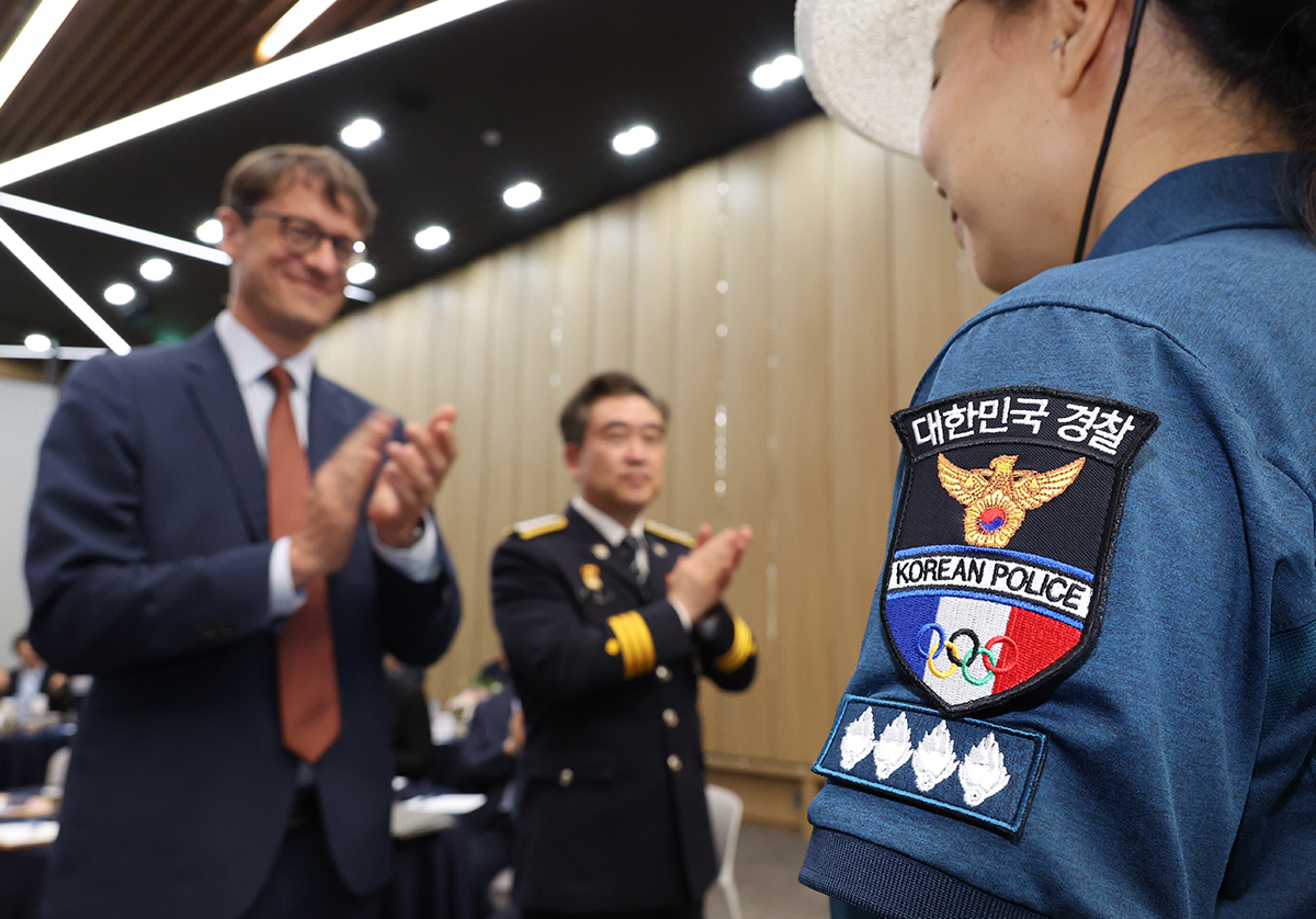 Korean National Police Agency (KNPA) Commissioner General Yoon Hee Keun and French Ambassador to Korea Philippe Bertoux on the afternoon of July 8 award badges at the launching ceremony for public safety volunteers for this year's Paris Summer Olympics and Paralympics at KNPA headquarters in Seoul's Seodaemun-gu District.