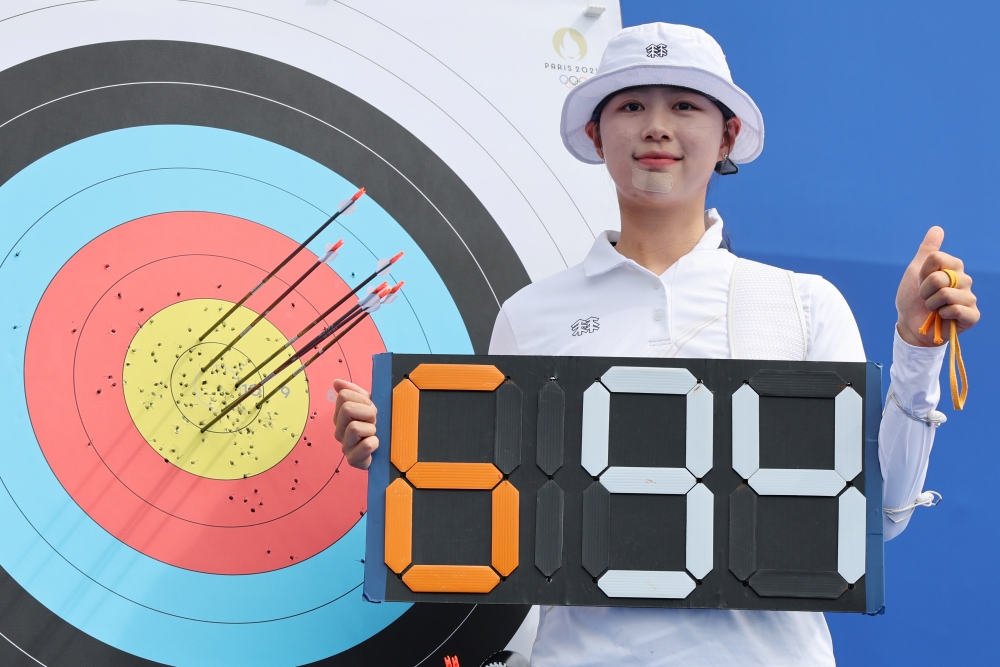 Lim Sihyeon on July 25 takes a photo in front of her target after setting a world-record 694 points in the women's archery individual ranking round of the Paris Summer Olympics at Les Invalides in the French capital.