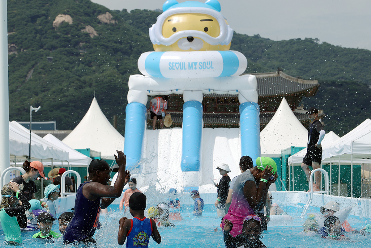 People on July 26 play in a makeshift pool in an event of the 2024 Seoul Summer Beach at Gwanghwamun Square in the capital's Jongno-gu District. The 17-day event ends on Aug. 11.