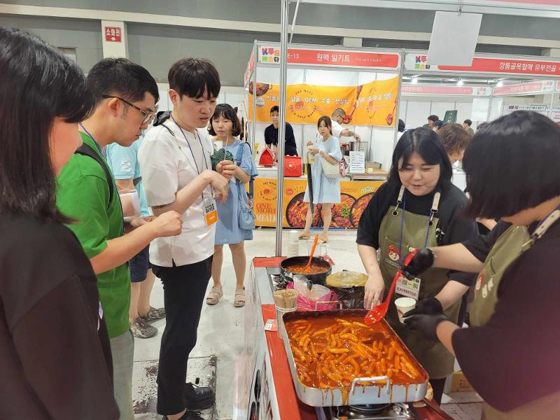 Visitors on July 19 taste tteokbokki (spicy rice cake) at this year's K-Food Festa at Exhibition Hall I of aT Center in the Yangjae-dong neighborhood of Seoul's Seocho-gu District.