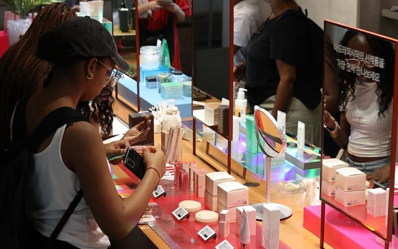The public and private sectors have teamed up to boost the global competitiveness of the domestic cosmetics and beauty sector. Shown is a woman in July last year trying products at a cosmetics store in Seoul. (Yonhap News) 