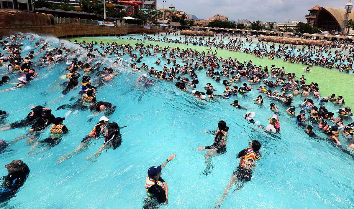 With a heat wave warning issued to most parts of the country, people at a water park in Gimhae, Gyeongsangnam-do Province, on the afternoon of Aug. 1 cool off in a massive pool with artificial waves.