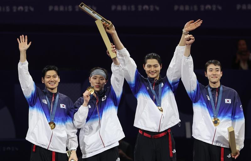 The national men's fencing team of (from left) Gu Bon-gil, Park Sang-won, Oh Sang-uk and Do Gyeong-dong on July 31 wave to the audience after winning the country's third straight gold medal in the men's team sabre by beating Hungary in the final at the Grand Palais in Paris.  