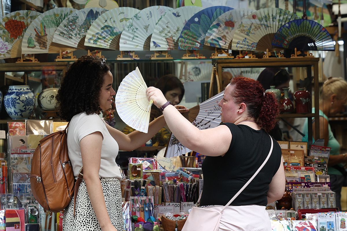 Foreign visitors on Sept. 19 in the Insa-dong neighborhood of Seoul's Jongno-gu District wave fans at each other amid the country's lingering record-high heat in late summer.