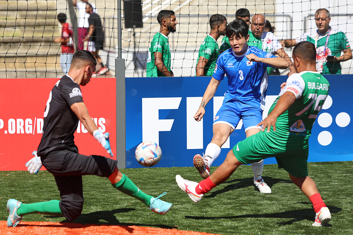Hong Seung-woo (in the blue uniform) on the afternoon of Sept. 23 takes a shot on goal in a men's Group A match against Bulgaria in the Homeless World Cup at a field of Hanyang University in Seoul