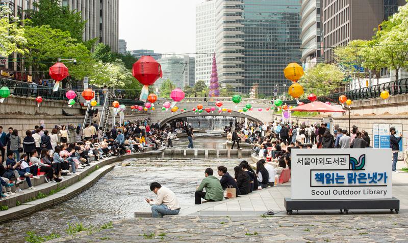 People read books at Seoul Outdoor Library along Cheonggyecheon Stream in Seoul. (Seoul Outdoor Library)