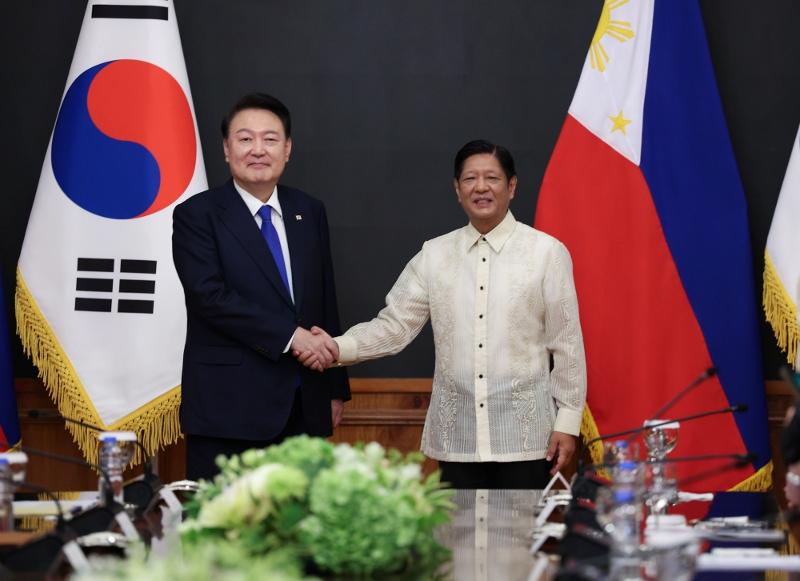 President Yoon Suk Yeol (left) on the morning of Oct. 7 poses for photos with Philippine President Ferdinand Marcos Jr ahead of their extended summit at the presidential Malacanang Palace in Manila. (Yonhap News)  