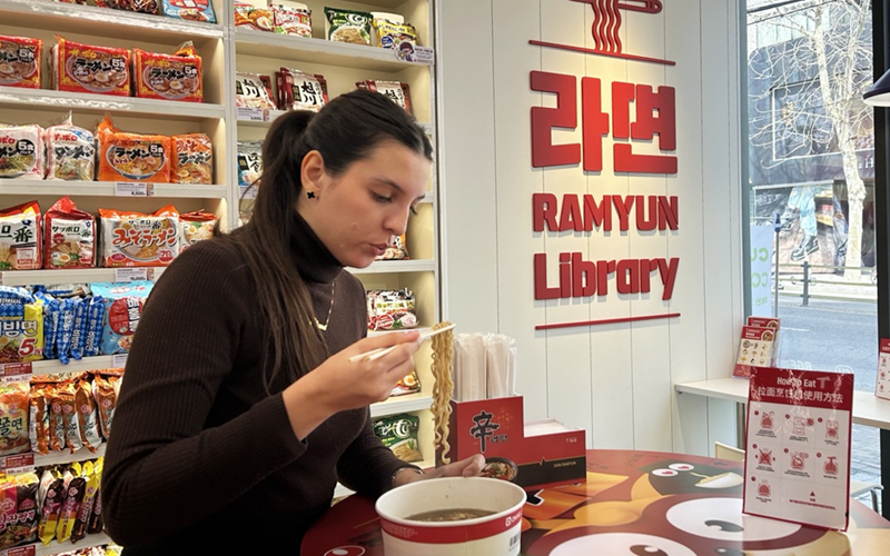 A foreign tourist on March 18 eats instant noodles at Ramyun (Instant Noodles) Library of the Hongdae Sangsang branch of the convenience store chain CU in Seoul's Mapo-gu District. (Hong Angie)  