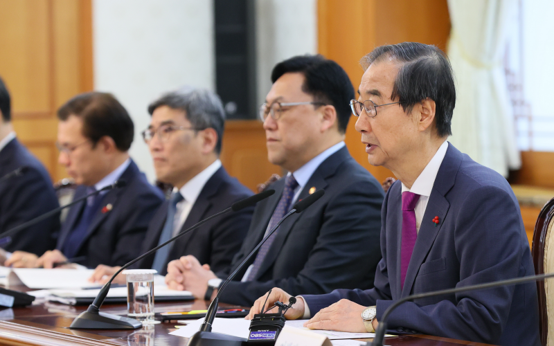 Acting President and Prime Minister Han Duck-soo (right) on Dec. 20 speaks at a meeting of the National High-Tech Strategic Industry Committee at Government Complex-Seoul in the capital's Jongno-gu District. (Prime Minister’s Office)  