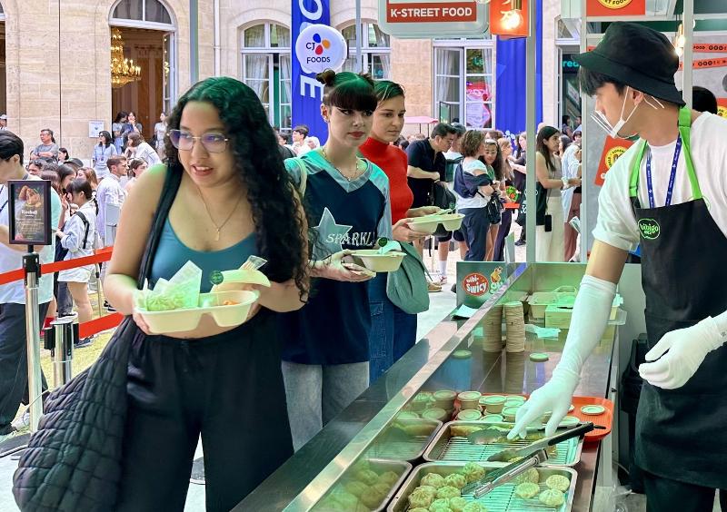 The Bibigo Market in Paris that ran from July 25 to Aug. 11 last year has visitors ordering foods with kimchi including mandu (dumplings), jumeokbap (rice balls) and corn dogs. (CJ Cheiljedang)