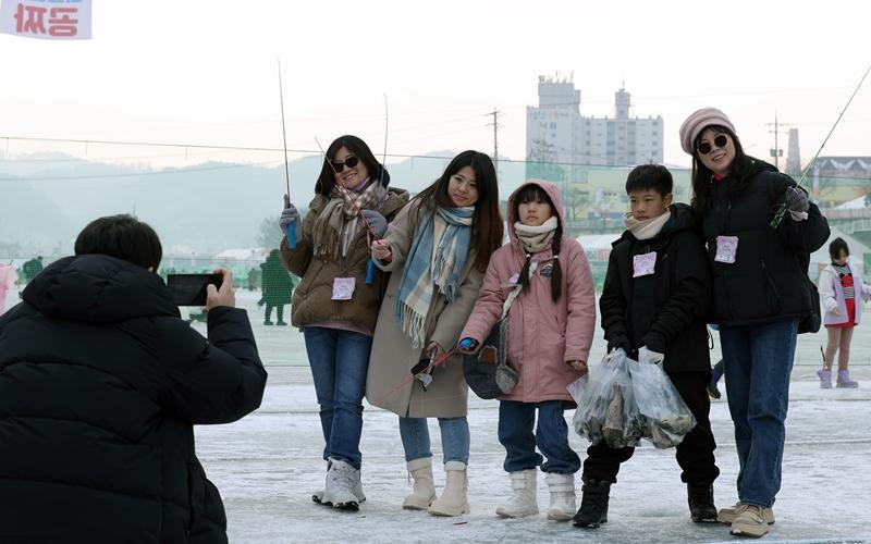Foreign tourists take a photo on Jan. 14 photo at the Hwacheon Sancheoneo (mountain trout) Ice Festival on Hwacheoncheon Stream in Hwacheon-gun County, Gangwon-do Province.  