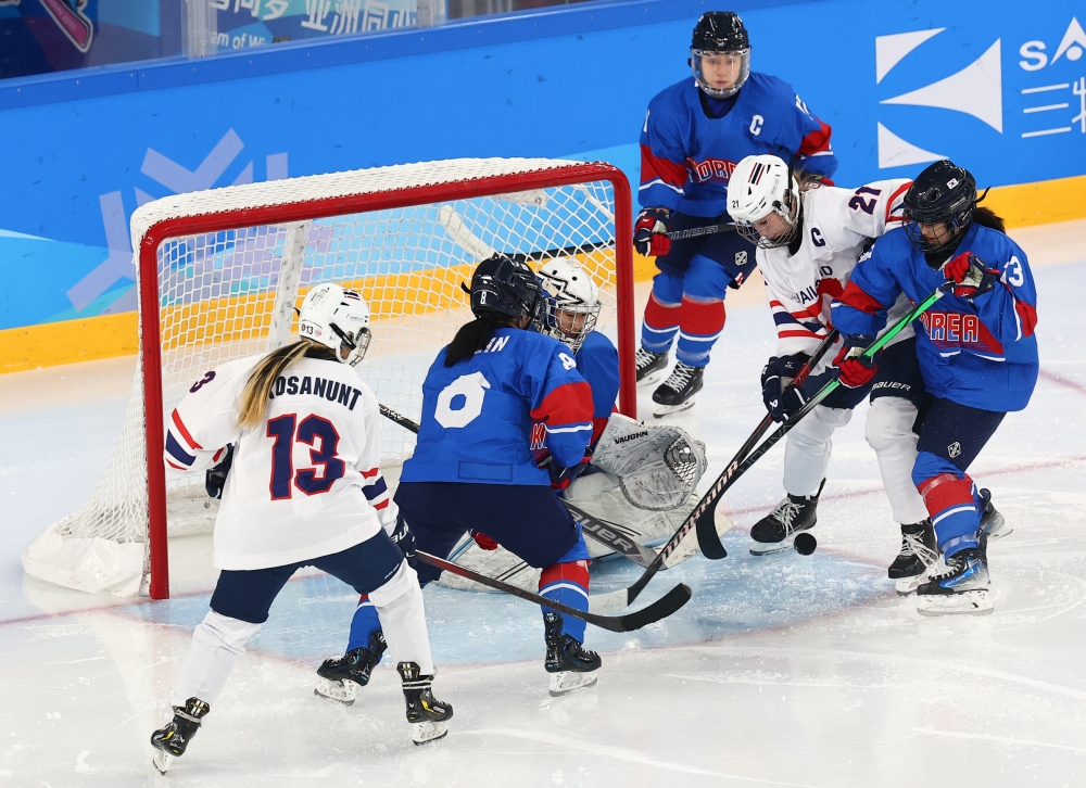 The national women's ice hockey team on Feb. 6 fights for the puck in a Group B game against Thailand at Harbin Sport University Student Ice Rink in Harbin, China.
