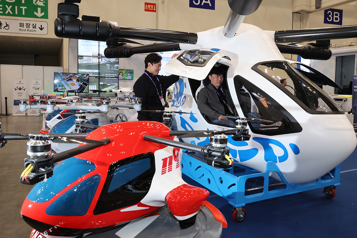 A visitor to Drone Show Korea 2025 at the Busan Exhibition and Convention Center, aka BEXCO, in Busan's Haeundae-gu District on Feb. 27 sits in a multipurpose vehicle for urban air mobility.