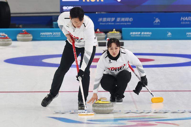 The mixed doubles curling team of Kim Kyungae and Seong Jihoon on Feb. 5 won its second consecutive match after losing the opener at the Asian Winter Games in Harbin, China. Shown is the duo on Feb. 4 in a Group B round-robin match against the Philippines at Harbin Pingfang District Curling Arena. (Yonhap News)